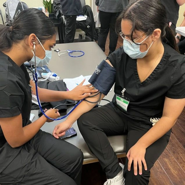 {{ school.name }} students training to take blood pressure counts